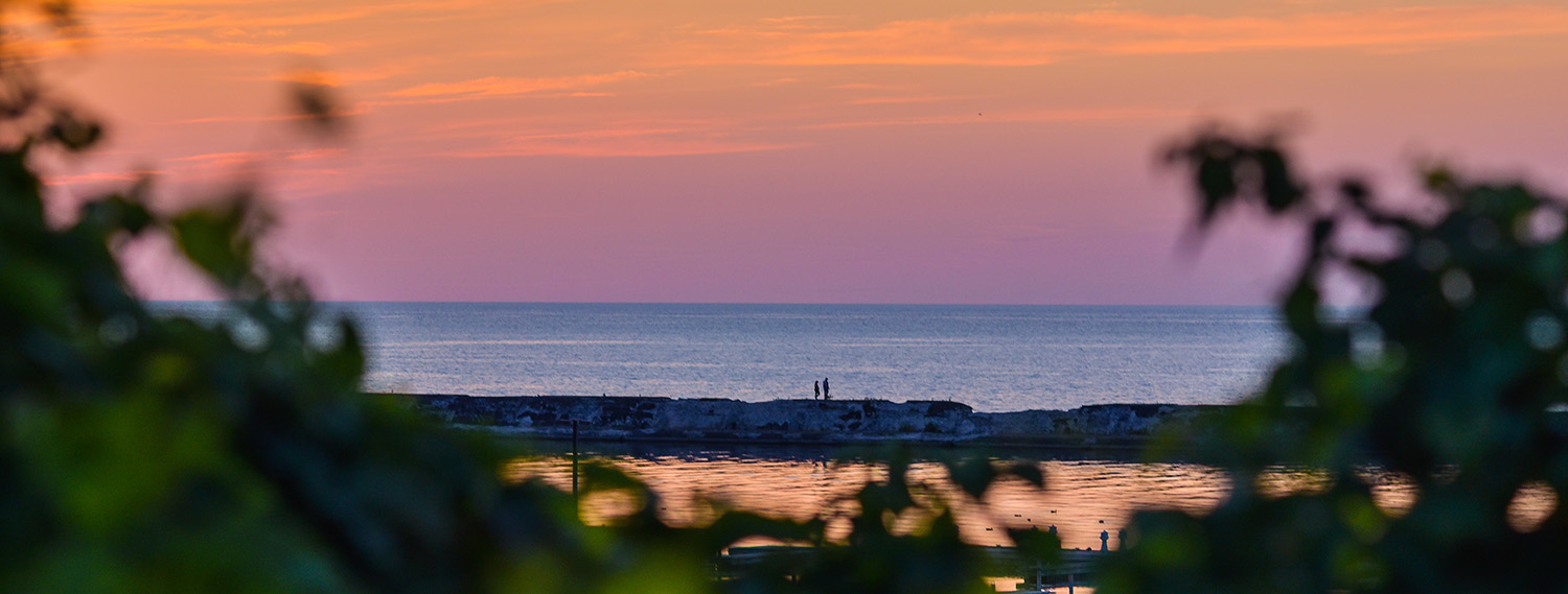 A photo of two people on the break wall in Oswego NY..